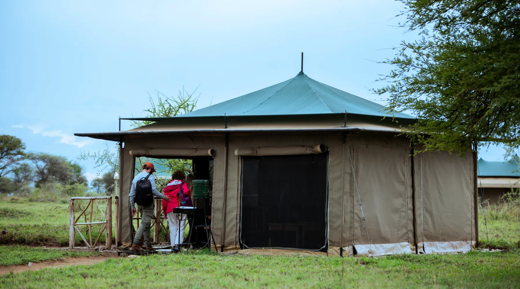 Travellers arriving at a canvas safari tent on the Serengeti plains